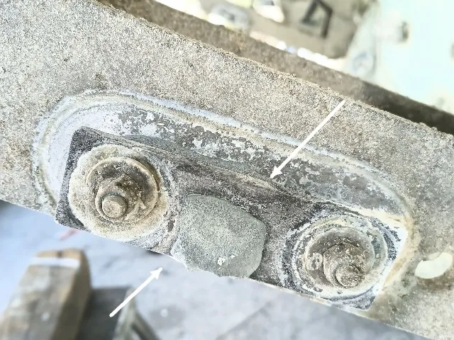 Gövdeye gömülü cıvatalı braket; tutya ileri düzeyde erimiş, pas izleri